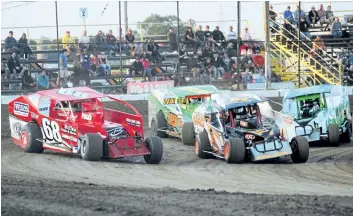  ?? BERND FRANKE/POSTMEDIA NEWS ?? Sportsman race cars go three wide rounding a corner at Merrittvil­le Speedway Saturday night in Thorold.