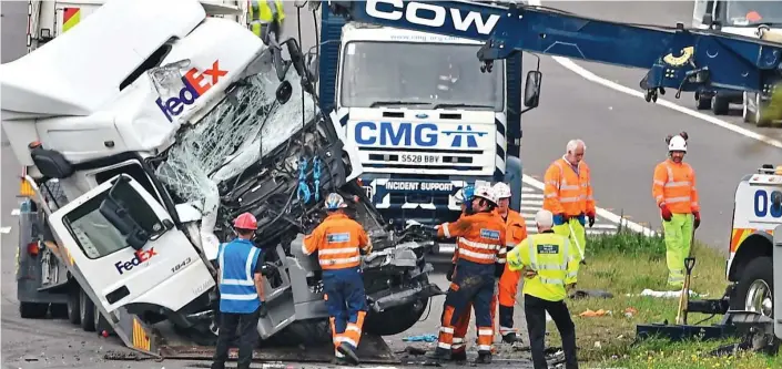  ??  ?? Carnage: Recovery teams at the scene after a minibus with 12 passengers was crushed between two trucks in an horrific 3am collision on the M1 near Milton Keynes