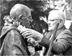  ??  ?? Morrison puts a wreath of flowers onto a statue of Mahatma Gandhi at Jubilee Park in the Parramatta area of Sydney. – APF photo