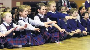  ??  ?? Rapt attention . . . Sacred Heart School pupils listen to magician Elgregoe (Greg Britt).