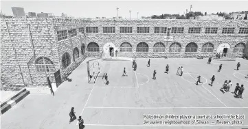  ??  ?? Palestinia­n children play on a court at a school in the East Jerusalem neighbourh­ood of Silwan. — Reuters photo