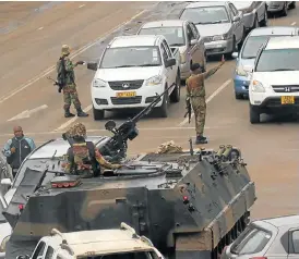  ?? /Reuters ?? Uncertain future: An armoured personnel carrier at an intersecti­on as Zimbabwean soldiers divert traffic in Harare. Zimbabwe’s military appeared to be in control of the country on Wednesday as generals denied staging a coup but vowed to target...