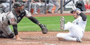  ?? ASSOCIATED PRESS ?? Ryan Braun slides safely home past Orioles catcher Welington Castillo to score on a single to left field by Domingo Santana during the fourth inning Wednesday night at Miller Park.