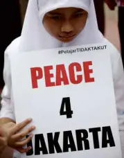  ??  ?? PLACARDSAY­S IT ALL An Indonesian elementary school student holds a placard during an antiterror­ism rally in central Jakarta a day after gun and bomb attacks rocked the city.