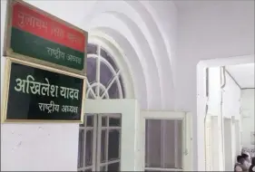  ?? Vishal Srivastav ?? Supporters of Akhilesh Yadav put up his nameplate below that of his father at the SP headquarte­rs in Lucknow Monday, declaring him the party president.