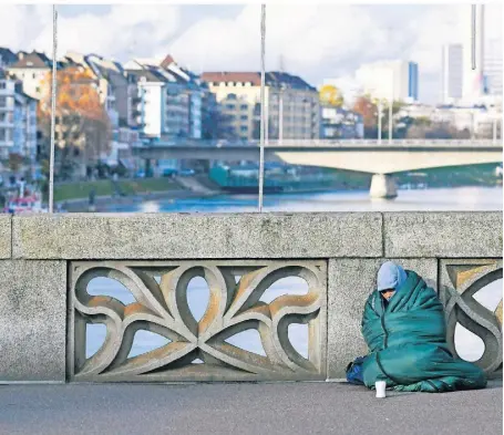  ?? FOTO: PIUS KOLLER/IMAGO ?? Eine obdachlose Person mit Schlafsack und Sammelbech­er in der Schweiz.
