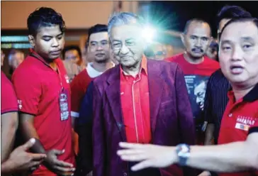  ?? MANAN VATSYAYANA/AFP ?? Former Malaysian Prime Minister and opposition prime ministeria­l candidate Mahathir Mohamad (centre) arrives at a gathering in Sekinchan, northwest of Kuala Lumpur, on Friday.