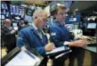  ?? RICHARD DREW — THE ASSOCIATED PRESS FILE ?? Trader Timothy Nick, center, works with specialist Michael O’Mara on the floor of the New York Stock Exchange.