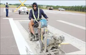  ?? JIM DAY/THE GUARDIAN ?? Andrew MacRae, a maintenanc­e technician with the Charlottet­own Airport Authority, repaints a runway designatio­n marker.