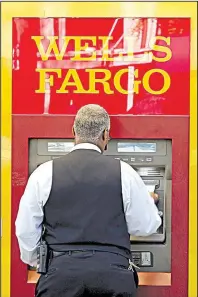  ?? AP/CHUCK BURTON ?? A customer uses a Wells Fargo ATM in Charlotte, N.C., in April.