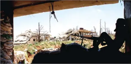  ?? TOBIAS SCHWARZ/AFP ?? A Syrian rebel fighter sits next to a machine gun in a fortified area near the frontlines at a rebel-held area in the southern Syrian city of Daraa on Sunday.