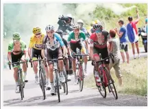  ??  ?? A spectator holds a flare as stage winner Colombia’s Rigoberto Uran, Britain’s Chris Froome, wearing the overall leader's yellow jersey, France's Romain Bardet, Colombia’s Nairo Quintana, Italy's Fabio Aru, and Australia's Richie Porte, from left,...