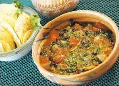  ??  ?? Black bean soup dusted with cilantro is served with tortilla chips.