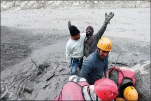  ?? (AP/Indo Tibetan Border Police) ?? A man rejoices Sunday after being pulled from a muddy hole by rescuers in India’s Uttarakhan­d state.