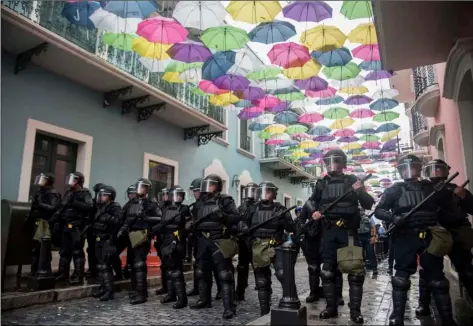  ?? AP PHOTO/CARLOS GIUSTI ?? Police block protesters from advancing to La Fortaleza governor’s residence in San Juan, Puerto Rico, on Sunday.