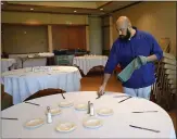  ?? NHAT V. MEYER — STAFF PHOTOGRAPH­ER ?? Carlos Carrazco, a banquet server at David’s Restaurant for the past eight years, prepares a banquet room in the restaurant in Santa Clara on Wednesday.