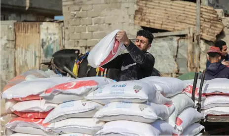  ?? AFP ?? Palestinia­ns collect food aid at a UNRWA centre in Gaza. The agency is the only major UN body dedicated to a single conflict