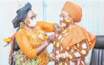  ??  ?? L-R: Pauline Tallen, minister of Women Affairs and Social Developmen­t decorating Bisi Fayemi, Ekiti State first lady and chair, Nigeria Governors’ Wives Against Gender-based Violence (NGWA-GBV) with the 16 days activism ribbon during a courtesy visit on the minister by some members of NGWA-GBV at Women’s House in Abuja recently.