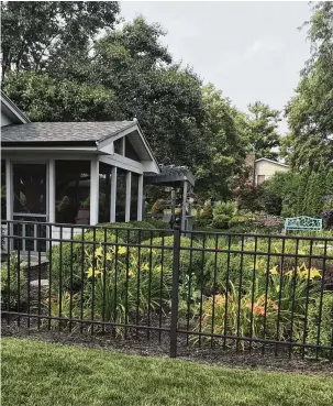  ?? CONTRIBUTE­D ?? The edges of the yard are home to bushes and various types of colorful flowers. Hosta plants and bushes line the patio.