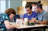  ?? Arkansas Democrat-gazette/william MOORE ?? Launch student Chelsea Durham, 23, of Farmington (left) works while teacher Joey Mcgarrah (right) helps student Allen Hixson, 18, of Magnolia with a presentati­on while eating lunch before class Wednesday in the Arkansas Union at the University of...