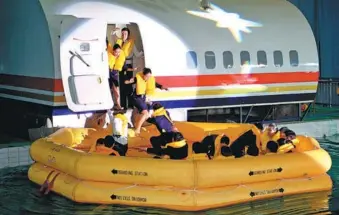  ?? LIU RANYANG / CHINA NEWS SERVICE ?? Flight attendants from airlines participat­e in an escape drill during a skills competitio­n in Kunming, Yunnan province, on Tuesday.