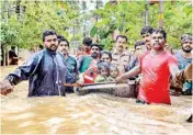  ?? PTI ?? Rescuers evacuate people from a flood-hit locality in Thiruvanan­thapuram