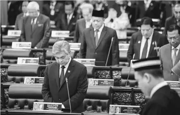  ??  ?? Zahid (front) and members of Parliament observe a moment of silence as a mark of respect for the late Sultan Abdul Halim Mu’adzam Shah at the Dewan Rakyat yesterday. — Bernama photo