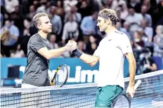  ?? — AFP photo ?? Switzerlan­d's Roger Federer (R) shakes hands with France's Adrian Mannarino after winning their quarter-final game at the Swiss Indoors ATP 500 tennis tournament on October 27, 2017 in Basel.