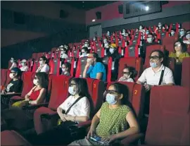  ?? Mark Schiefelbe­in Associated Press ?? MOVIEGOERS watch “Dolittle” last week in Beijing, where theaters have partially reopened. U.S. studios have long sought a greater box office share in China.