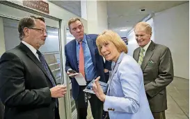  ?? [AP PHOTO] ?? From left, Rep. Gary Peters, D-Mich., Sen. Mark Warner, D-Va., Sen. Maggie Hassan, D-N.H., and Sen. Bill Nelson, D-Fla., return to the Capitol after a meeting Sunday of moderate senators on Day 2 of the federal shutdown.