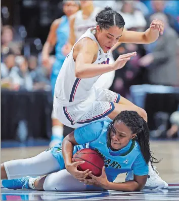  ?? SEAN D. ELLIOT/THE DAY ?? UConn’s Gabby Williams goes tumbling over Tulane’s Tatyana Lofton (11) going after a loose ball in the first half of Sunday’s American Athletic Conference women’s basketball quarterfin­al at Mohegan Sun Arena.