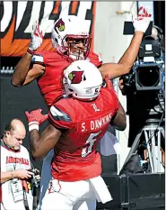  ?? AP/TIMOTHY D. EASLEY ?? celebrates with teammate Seth Dawkins (5) after a touchdown Saturday during the No. 17 Cardinals’ 55-10 victory over Murray State in Louisville, Ky.