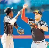  ?? JIM MCISAAC/GETTY IMAGES ?? Giancarlo Stanton and Dee Gordon, left, celebrate after Sunday’s victory over the New York Mets.