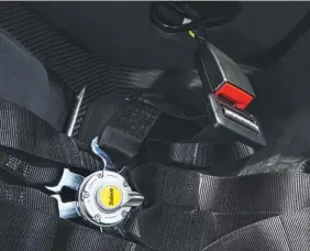  ??  ?? Six-point racing harnesses are standard; three-point seatbelts in addition a nocost option. Inboard belt strap of the six-pointer attaches to the inertia-reel latch.