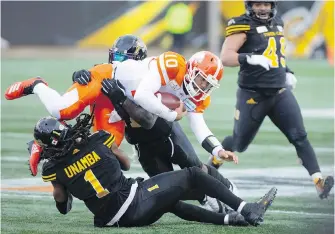  ??  ?? B.C. Lions quarterbac­k Jonathon Jennings (10) is sacked by Tiger-Cats defensive back Don Unamba (1) and linebacker Larry Dean (11) during the second half of play in Hamilton, Ont., on Sunday.