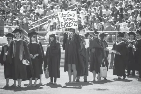  ?? RAMIN TALAIE/GETTY IMAGES ?? Graduating student Andrea Lorei, who helped organize campus demonstrat­ions, holds a sign in protest during the 125th Stanford University commenceme­nt ceremony on June 12. The Brock Turner case at Stanford has focused unpreceden­ted attention on campus...