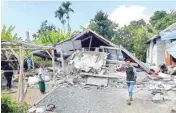  ?? PIC/PTI ?? Villagers walk near destroyed homes in an area affected by the early morning earthquake at Sajang village, Sembalun, East Lombok in Indonesia on Sunday