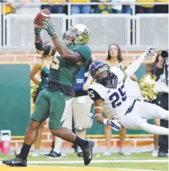  ?? Jerry Larson, Waco Tribune-Herald ?? Baylor wide receiver Antwan Goodley pulls down a 28-yard touchdown reception from star quarterbac­k Bryce Petty over Texas Christian safety Michael Downing with 6:39 left in Saturday’s game, pulling the Bears within 58-51.