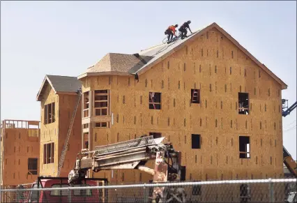  ?? Hearst Connecticu­t Media file photo ?? Constructi­on proceeds in September at the Windward Commons apartment project in Bridgeport. A year after Connecticu­t builders put in an estimated 1,700 more permits for new apartments than single- family homes, the pendulum swung back in 2020 as city dwellers sought elbow room in the suburbs during the COVID- 19 pandemic.