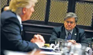  ?? EVAN VUCCI/THE ASSOCIATED PRESS ?? White House Chief Strategist Steve Bannon, right, listens as President Donald Trump speaks during a meeting in January. Trump removed Bannon, his chief strategist, from the National Security Council’s Cabinet-level ‘principals committee’ on Wednesday.