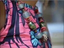  ??  ?? Amoah’s Ghanaian necklace is made from recycled glass beads.
“I’m not a huge purse person, I don’t ever have a big tote,” she says. Her mini leather crossover bag with elephant motif is from Ghana.