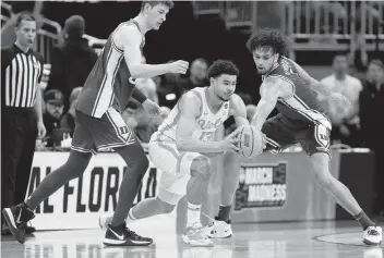  ?? RUSSELL LANSFORD USA TODAY NETWORK ?? Tennessee forward Olivier Nkamhoua looks for an opening to pass between Duke defenders Kyle Filipowski, left, and Dereck Lively II during the second half of Saturday afternoon’s East Region game at Orlando.