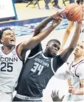  ?? BUTLER II/AP
DAVID ?? UConn forward Josh Carlton (25) works for the rebound against Georgetown center Qudus Wahab (34) during the first half Saturday in Storrs.