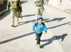  ?? — Reuters ?? A child walks in front of Iraqi army during an operation in the neighbourh­ood of Intisar in eastern Mosul.
