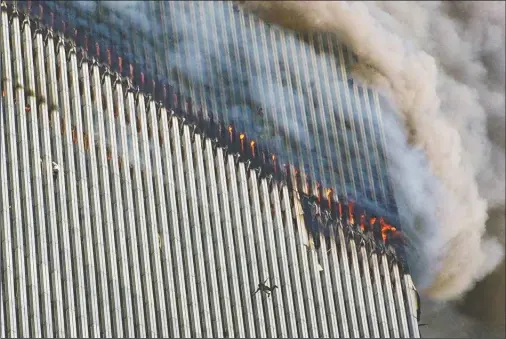 ?? (AP/Richard Drew) ?? A person falls from the north tower of New York’s World Trade Center as another clings to the outside (left) while smoke and fire billow from the building Sept. 11, 2001.