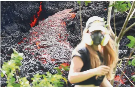  ?? — AFP ?? Red hot spot: A resident walking past lava flowing out of a new fissure in the aftermath of eruptions from the Kilauea volcano on Hawaii’s Big Island.