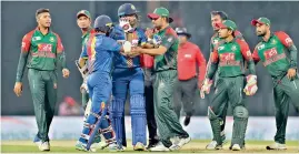  ??  ?? — AP Sri Lanka’s Kusal Mendis (second from left) and Bangladesh player Tamim Iqbal are in a heated exchange during a Twenty20 match in the Nidahas triangular series.