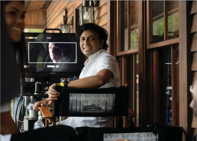  ?? UNIVERSAL PICTURES VIA AP ?? Director and co-writer M. Night Shyamalan on the set of his film “Knock at the Cabin,” his latest mashup of mystery and menace.