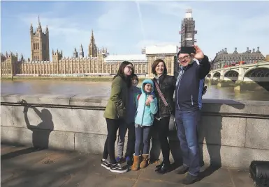  ?? Jonathan Brady / PA Images ?? Top: Tourists take a selfie on the Thames River in London. All of Great Britain has fewer homeless on its streets, some 5,100, than does the city of S.F.