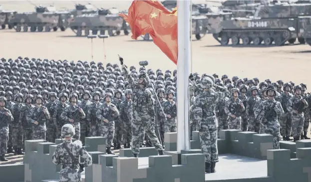  ?? AFP PHOTO ?? 0 The Chinese flag is raised at the military parade at the Zhurihe training base in China’s northern Inner Mongolia region yesterday